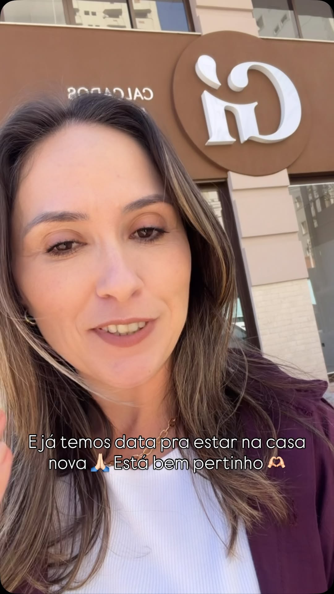 Fundadora em frente à fachada com o novo logo da loja